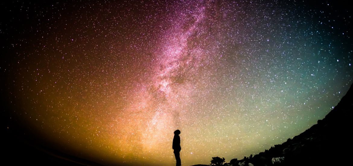 Distant Silhouette Of A Man Looking At Milky Way Galaxy